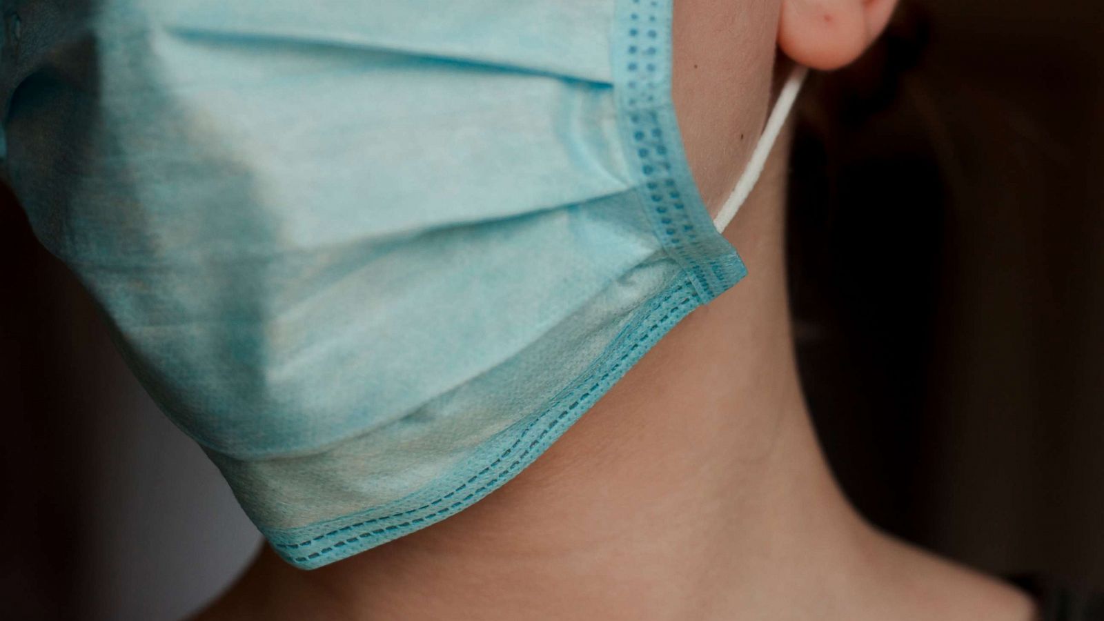 PHOTO: A young woman wears a blue medical mask in an undated stock photo.