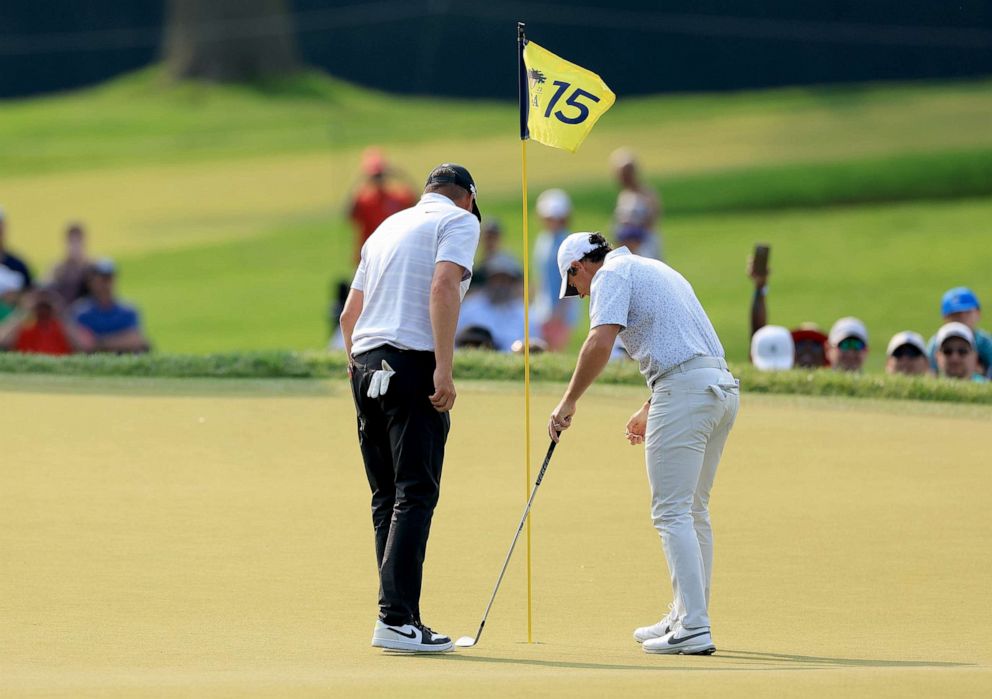 PHOTO: Michael Block, examines the hole for damage after he had holed-in-one on the 15th hole with his playing partner Rory McIlroy during the final round of the 2023 PGA Championship at Oak Hill Country Club on May 21, 2023 in Rochester, N.Y.