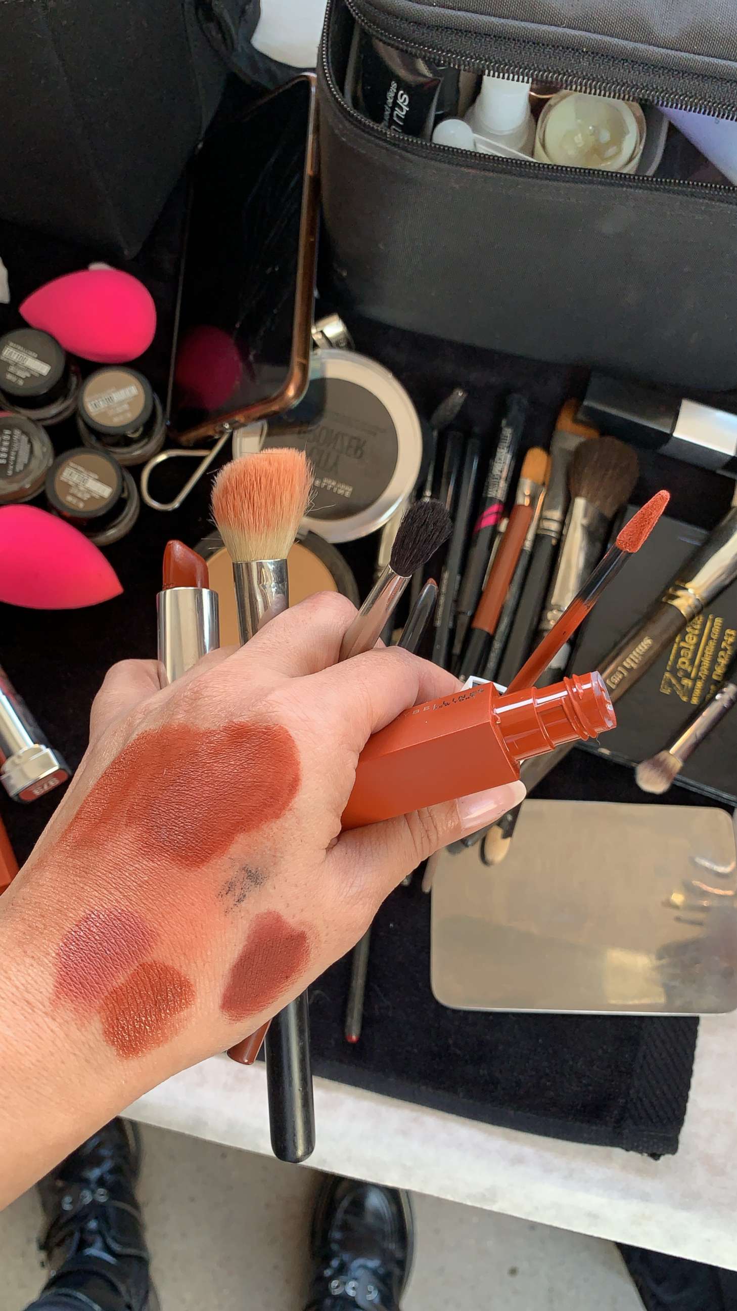 PHOTO: Grace Lee swatches products backstage before Cushnie's fall 2019 show. 