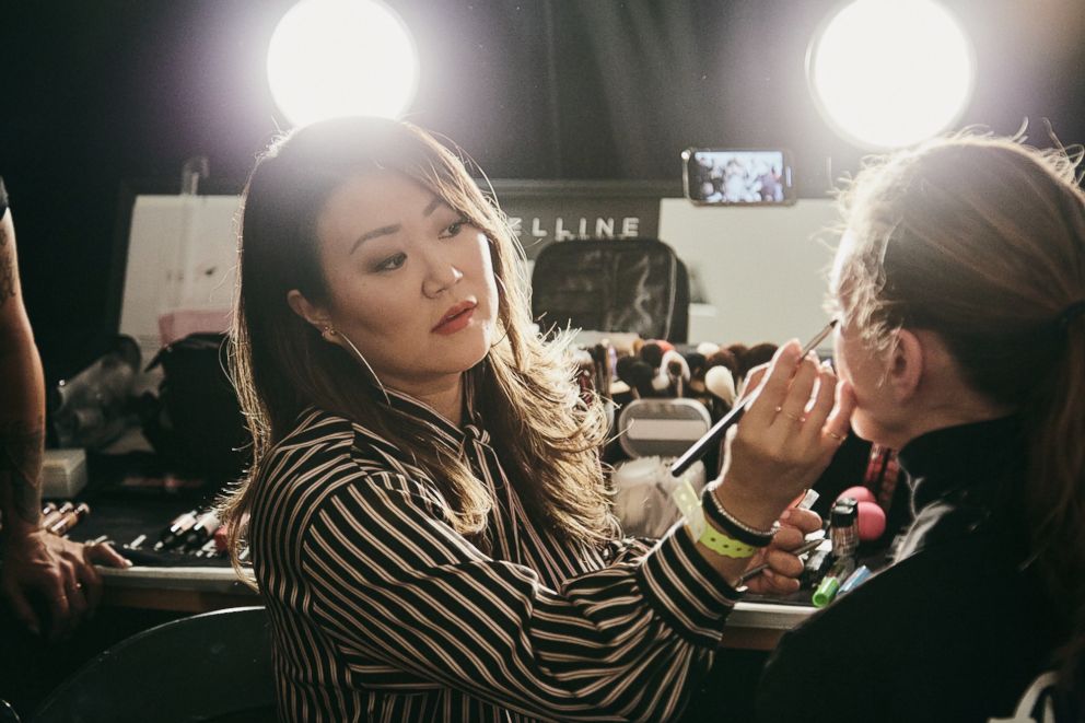 PHOTO: Grace Lee applying makeup on a model backstage at Rebecca Minkoff.
