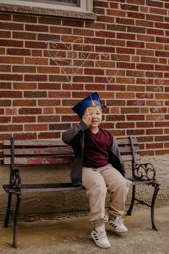 PHOTO: A student poses on a bench in a graduation cap in Fairborn, Ohio.