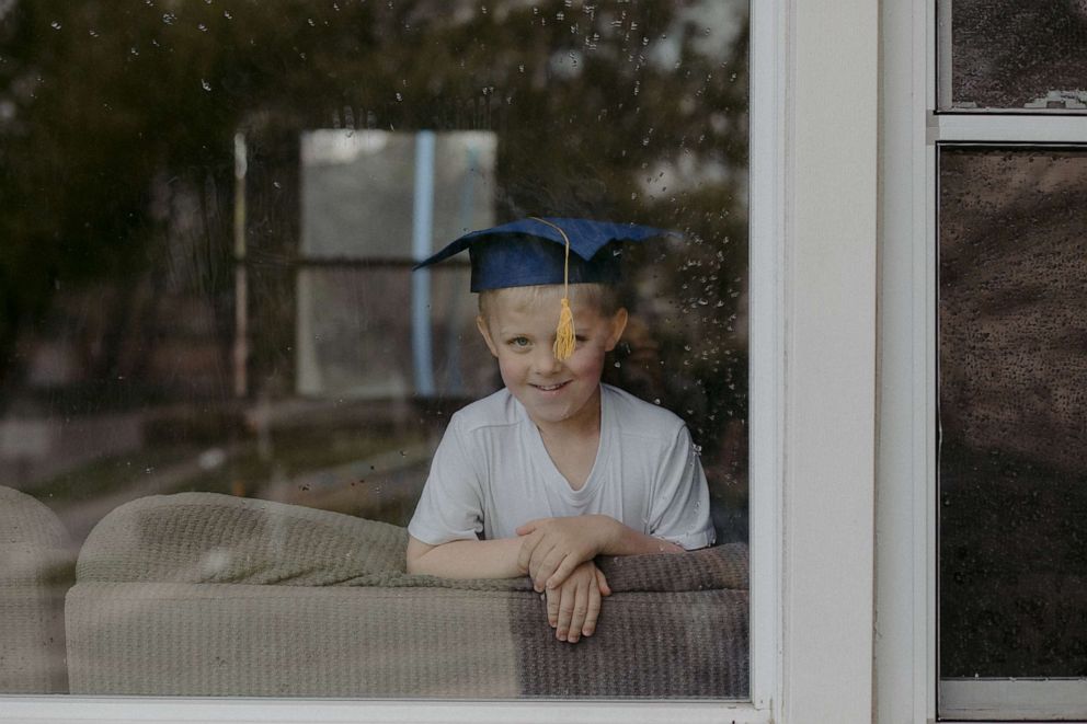 PHOTO: A graduate smiles behind a window in Fairborn, Ohio.