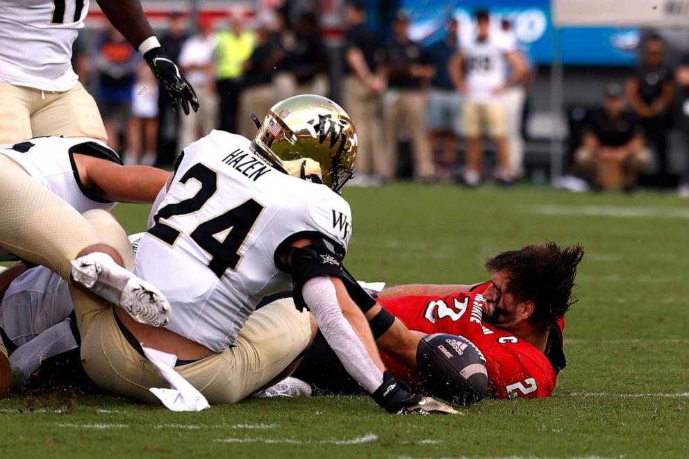 PHOTO: Grayson McCall #2 of the NC State Wolfpack falls to the ground after a hit by Dylan Hazen #24 of the Wake Forest Demon Deacons during the first half of the game at Carter-Finley Stadium Oct. 5, 2024 in Raleigh, North Carolina.