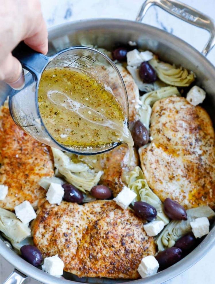 PHOTO: A skillet of Greek chicken ingredients is topped with marinade liquid.