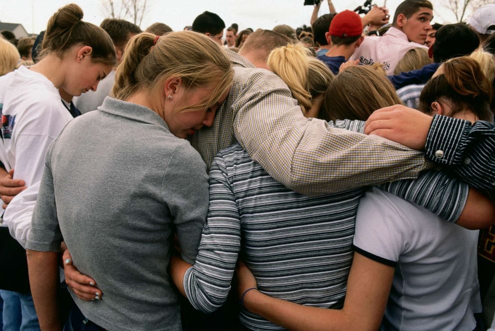 PHOTO: Students huddle together in comfort while gathered at a memorial for the victims of the Columbine shooting in Littleton, Colo.