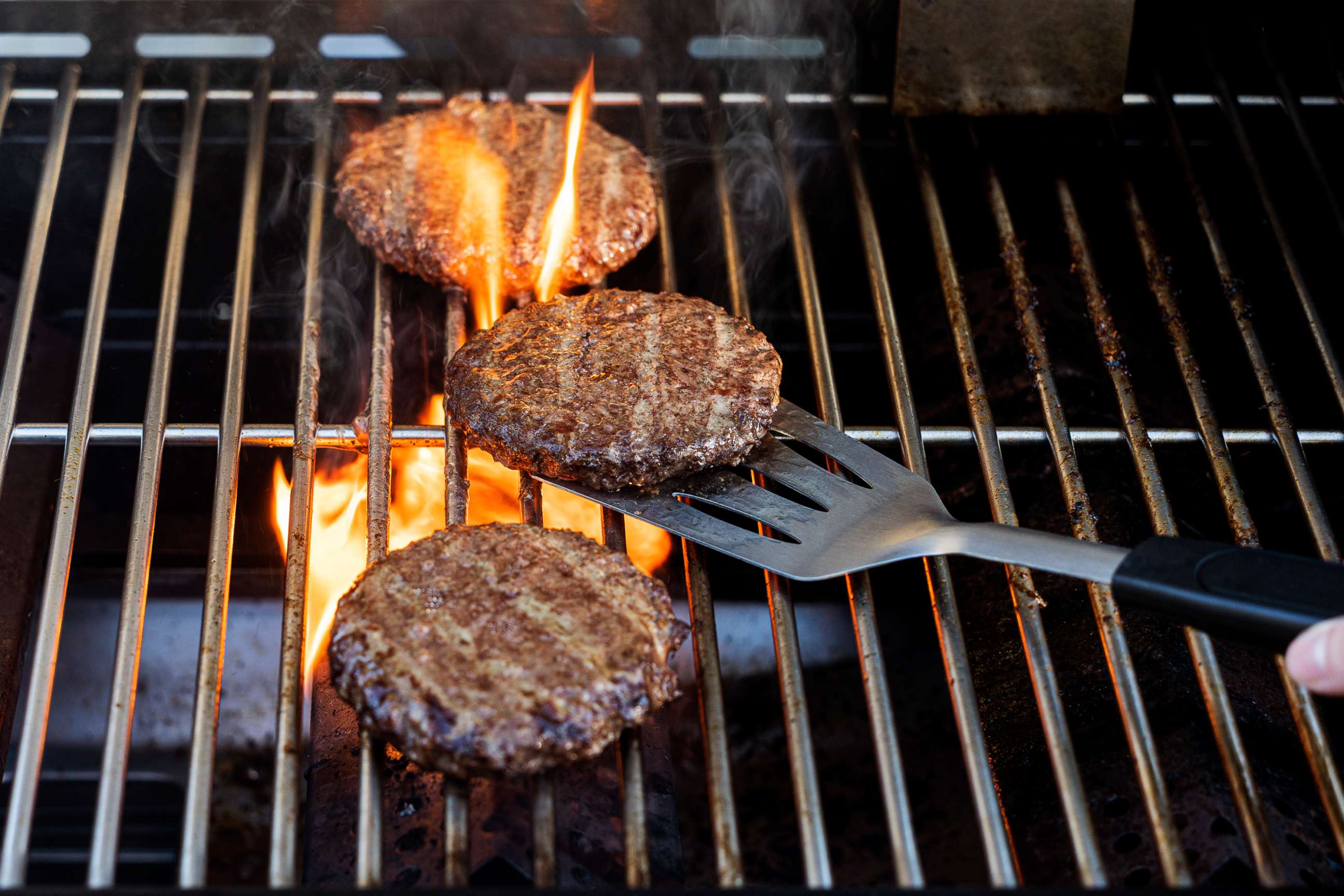PHOTO: Burgers cooking on a barbecue grill.