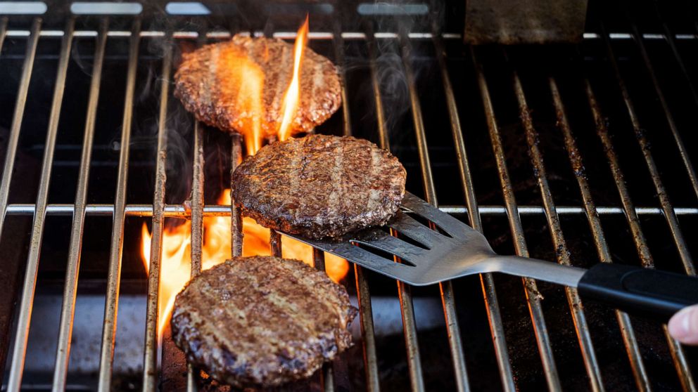 PHOTO: Burgers cooking on a barbecue grill.