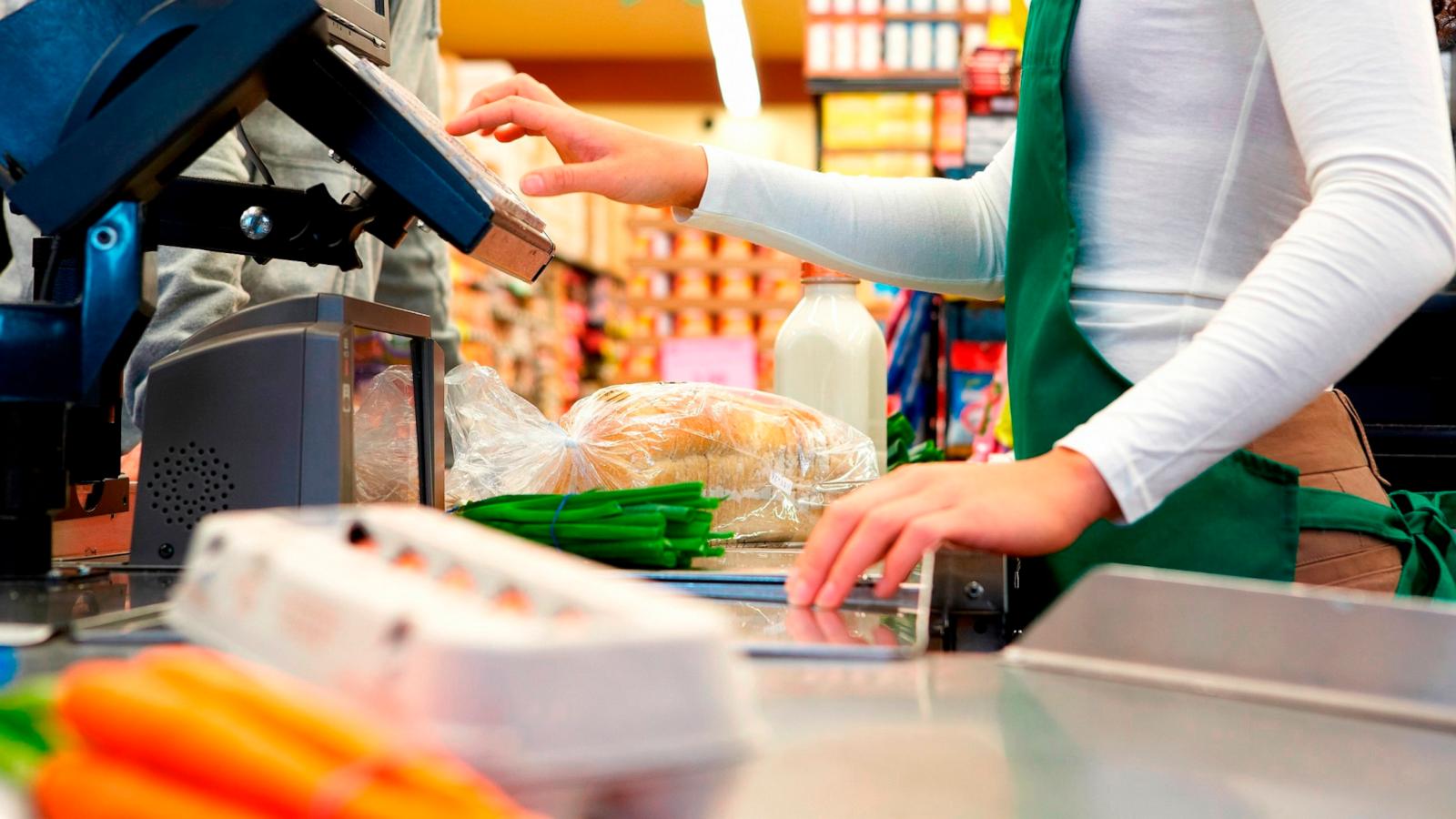 PHOTO: Stock photo of a cashier scanning groceries.