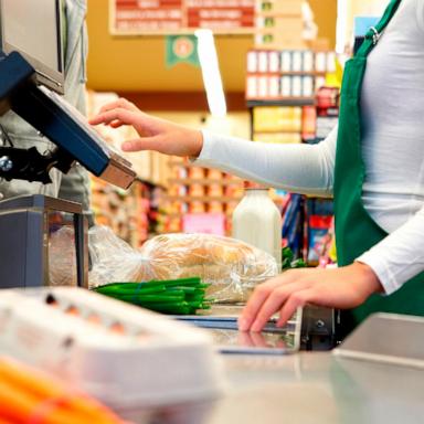 PHOTO: Stock photo of a cashier scanning groceries.