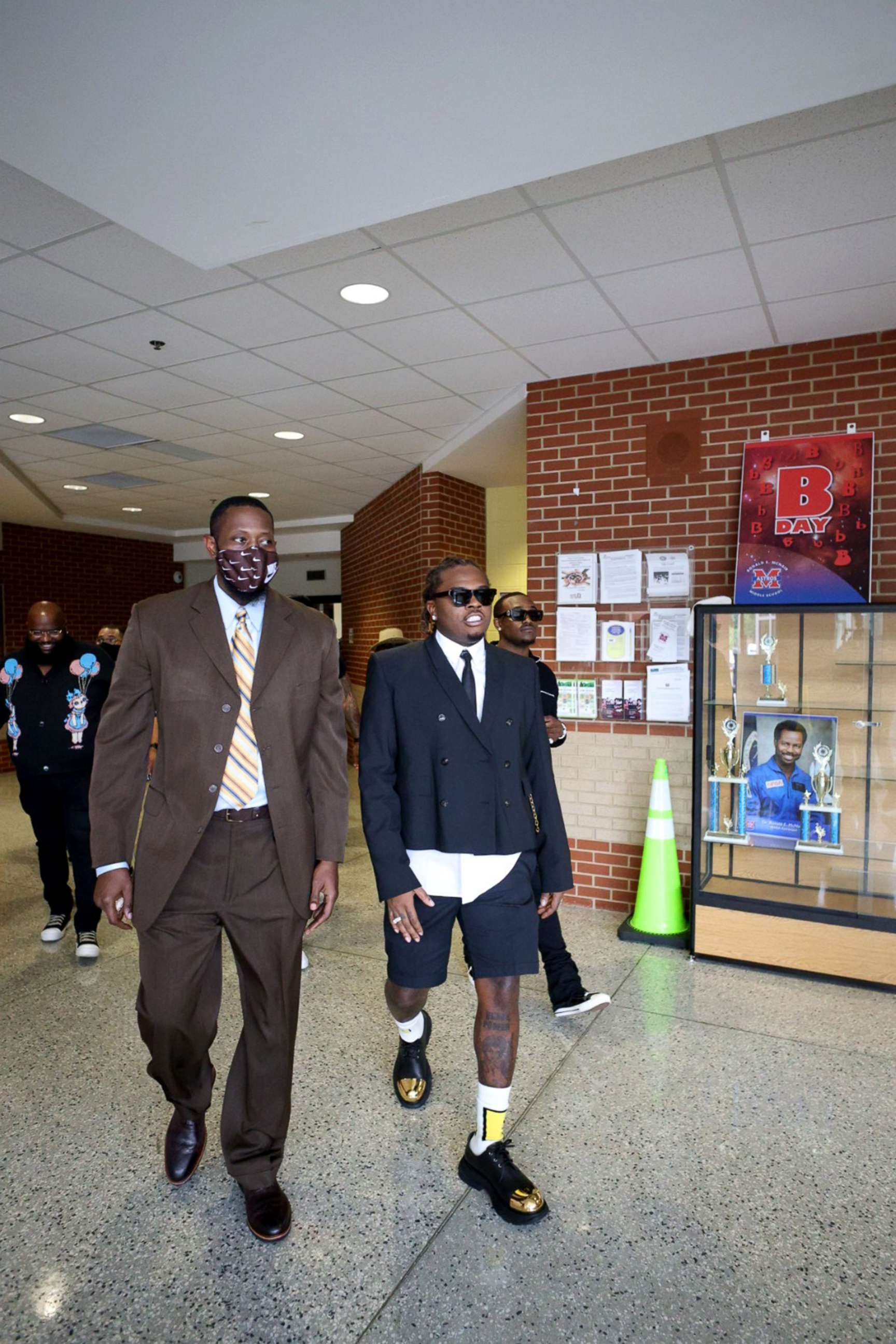 PHOTO: Hip-hop artist Gunnar walks with McNair Middle School principal John T. Madden Jr., on Sept. 16, 2021.