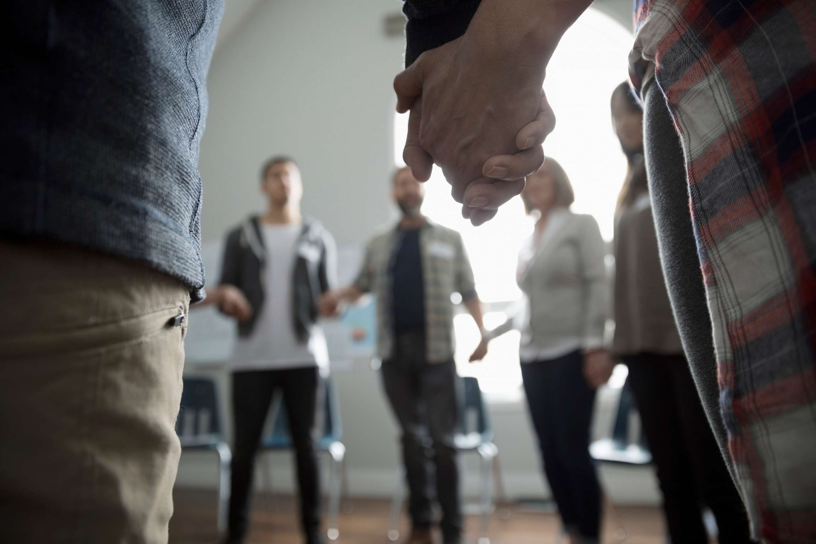 PHOTO: An undated stock photo shows a group of people holding hands in a circle.