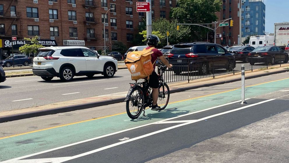 PHOTO: GrubHub delivery person on electric bike in the bicycle lane on Queens Boulevard in Queens, N.Y.