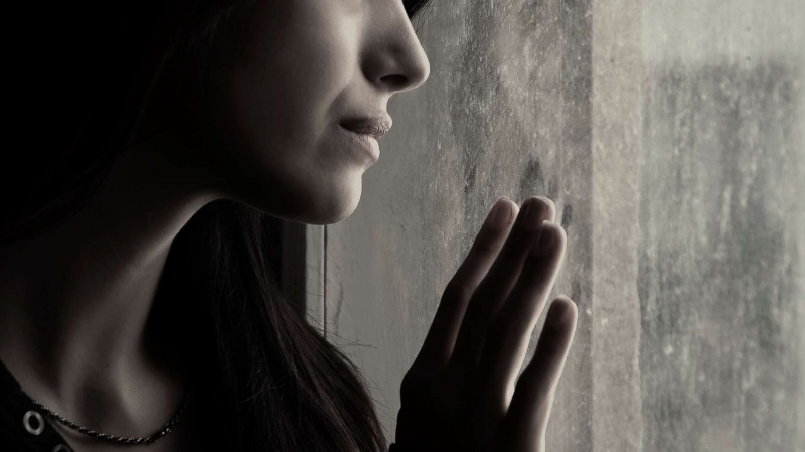 PHOTO: A stock photo depicts a woman looking out a window.