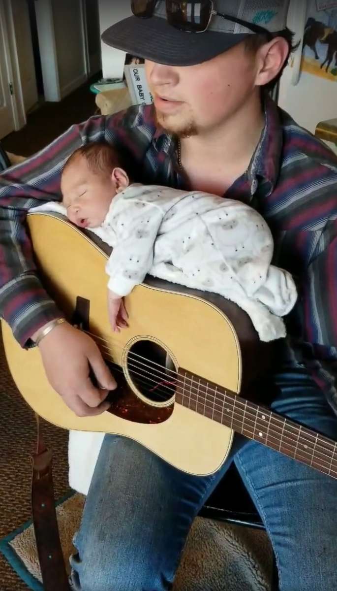PHOTO: Cody Comer, 21, used his guitar to lull his daughter, Carrigan, to sleep.