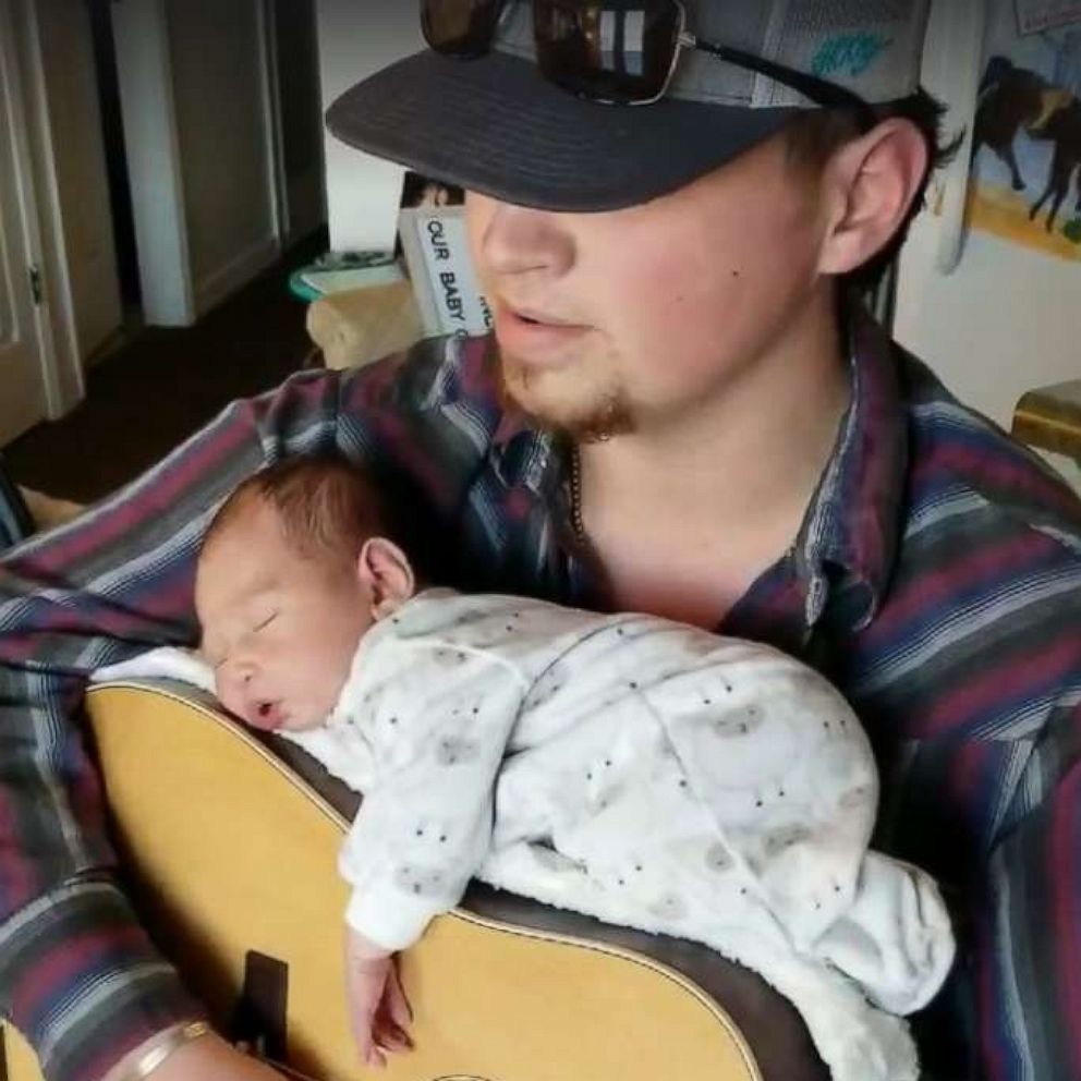 VIDEO: Dad nestles his newborn daughter on top of his guitar to lull her to sleep