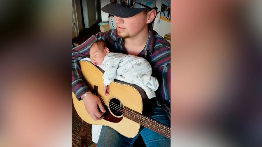 PHOTO: Cody Comer, 21, used his guitar to lull his daughter, Carrigan, to sleep.