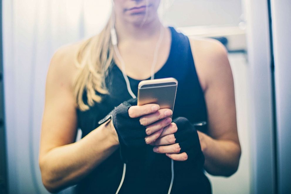 PHOTO: A woman using a smart phone while exercising at the gym is pictured in this undated stock photo.