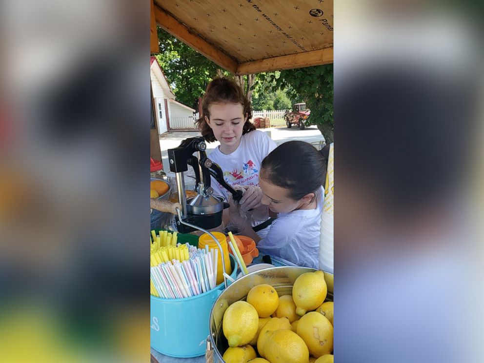 PHOTO: Sisters Hailey and Hannah Hager squeeze lemons at one of their lemonade stands in North Carolina.
