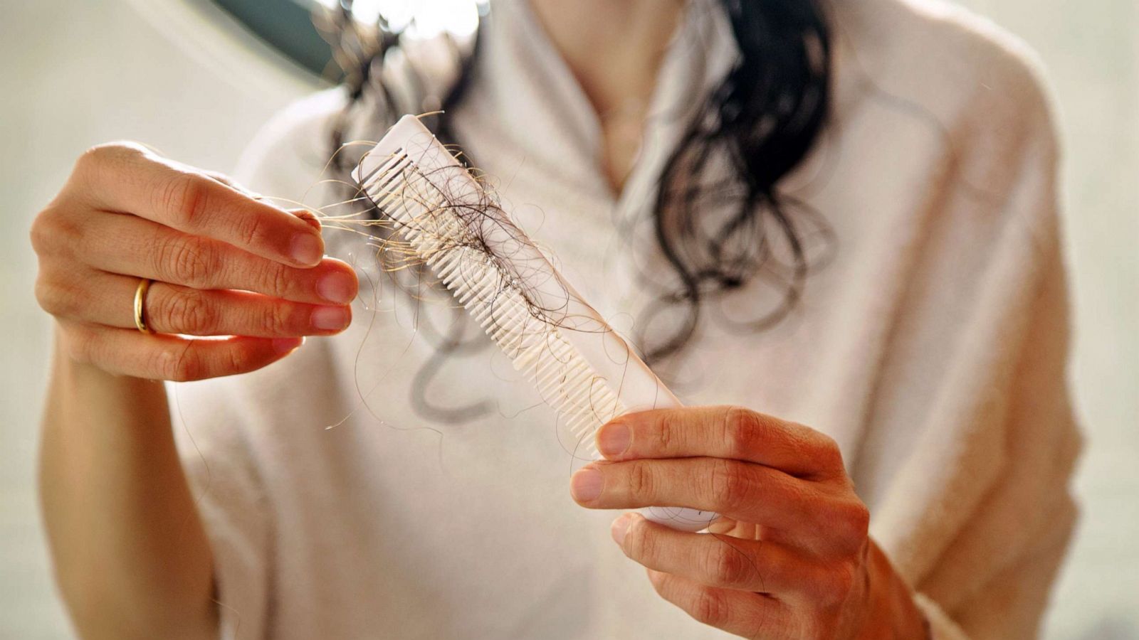 PHOTO: An undated stock photo depicts a woman pulling hair from a comb.