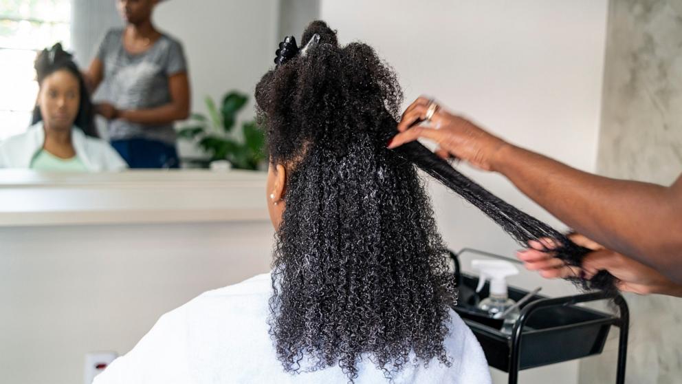 PHOTO: Stock photo of a woman getting her hair straightened at a salon.