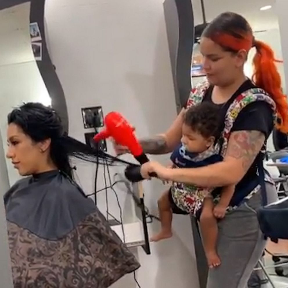 VIDEO: Hair stylist wears baby at work because moms get it done 