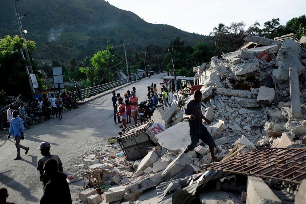 PHOTO: A man walks on a collapsed building in Saint-Louis-du-Sud, Haiti, Aug. 16, 2021.