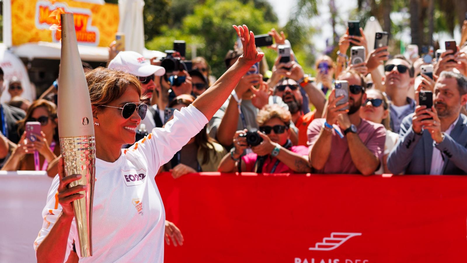 PHOTO: Actress Halle Berry carries the Olympic Torch in front of the Palais des Festivals during the Cannes Lions International Festival Of Creativity 2024 - Day Two on June 18, 2024 in Cannes, France.