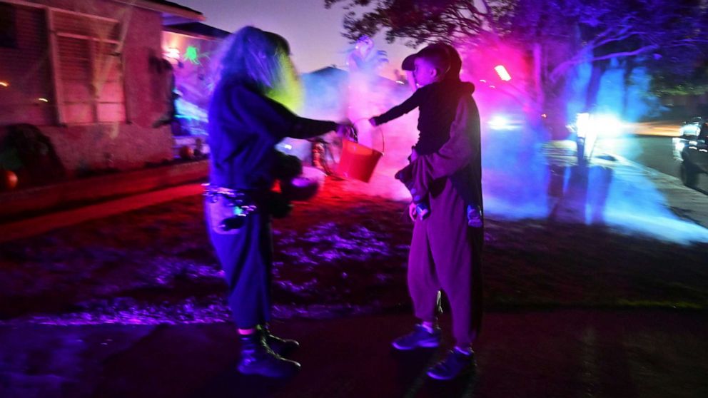 PHOTO: A child receives candy while trick or treating on Halloween night in Monterey Park, Calif., Oct. 31, 2019.
