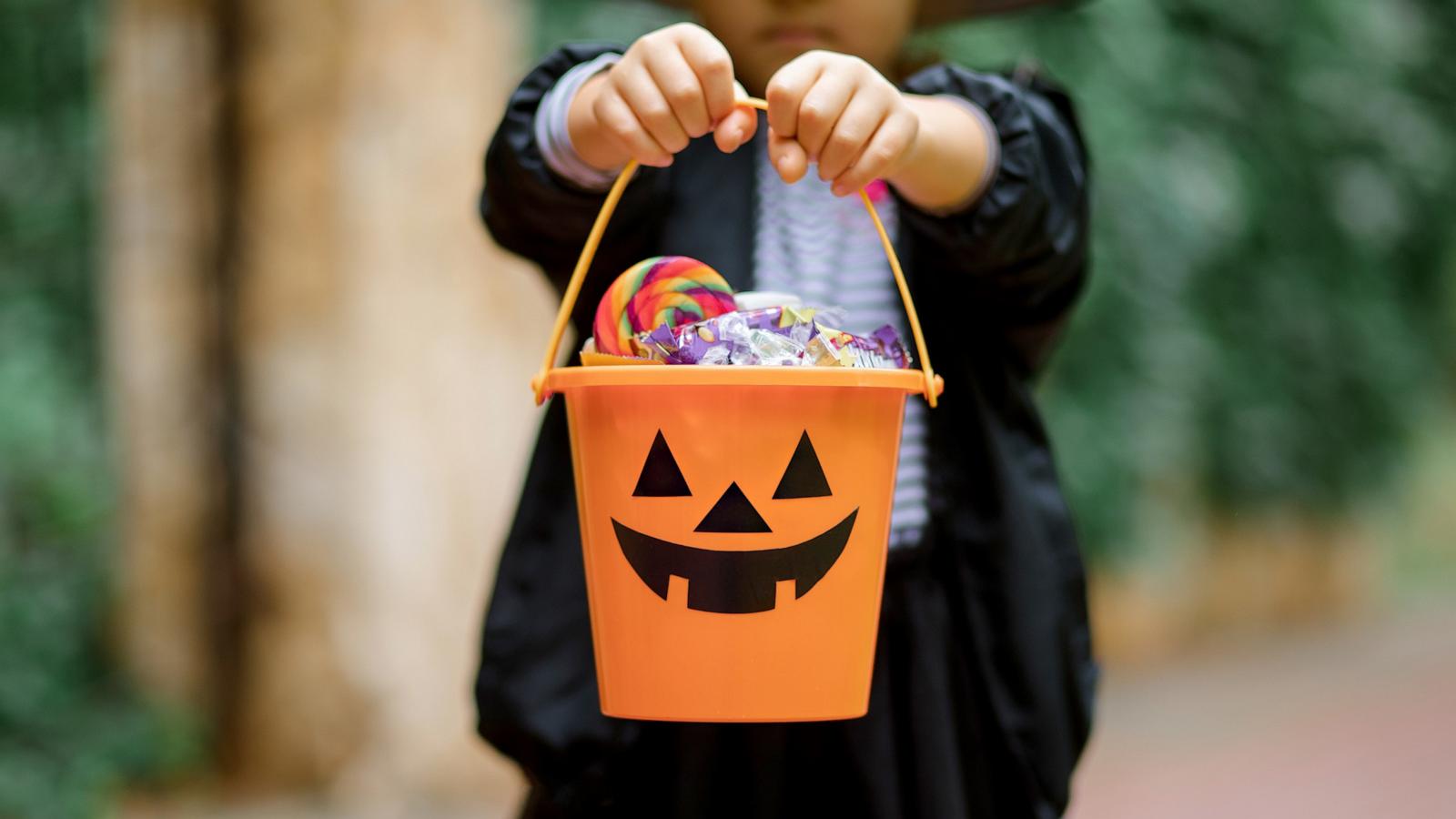 PHOTO: Stock photo of a child with Halloween candy in a pumpkin bucket.