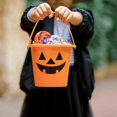 PHOTO: Stock photo of a child with Halloween candy in a pumpkin bucket.