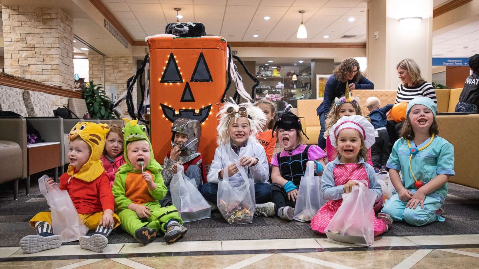 PHOTO: Children in costumes sit with a TUG robot decorated as a jack-o'-lantern for a Halloween event at UPMC Presbyterian hospital in Pittsburgh, Oct. 26, 2018.