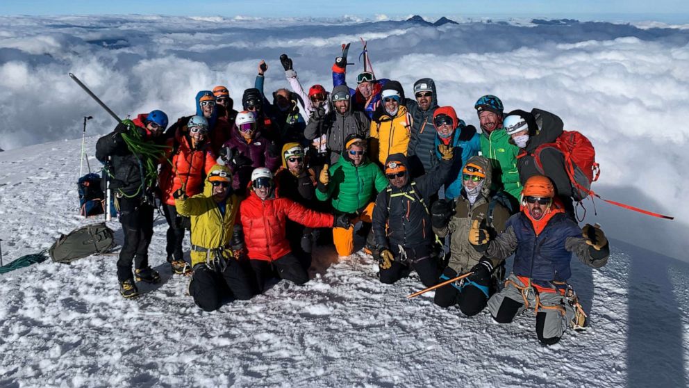 PHOTO: Friends and family of rock climber Emily Harrington and mountaineer Adrian Ballinger pose for a photo at the summit of Cotopaxi in Ecuador on Dec. 7, 2021, a few days before the couple's wedding.