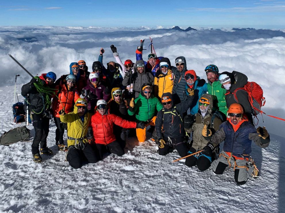 PHOTO: Friends and family of rock climber Emily Harrington and mountaineer Adrian Ballinger pose for a photo at the summit of Cotopaxi in Ecuador on Dec. 7, 2021, a few days before the couple's wedding.