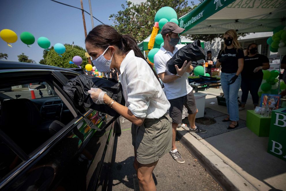 PHOTO: Prince Harry and Meghan hand out supplies to families at a Baby2Baby drive-through event at Dr. Owen Lloyd Knox Elementary School in South Los Angeles.