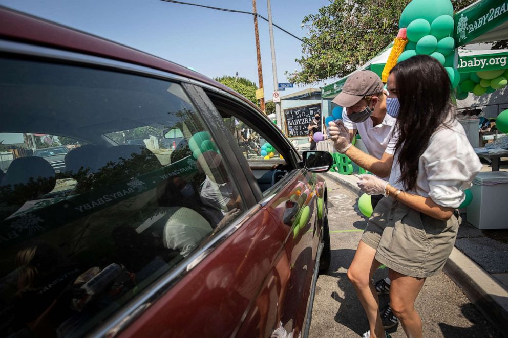 PHOTO: Prince Harry and Meghan hand out supplies to families at a Baby2Baby drive-through event at Dr. Owen Lloyd Knox Elementary School in South Los Angeles.