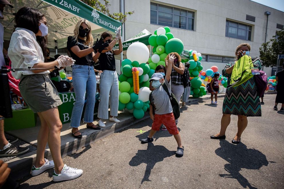 PHOTO: Prince Harry and Meghan hand out supplies to families at a Baby2Baby drive-through event at Dr. Owen Lloyd Knox Elementary School in South Los Angeles.