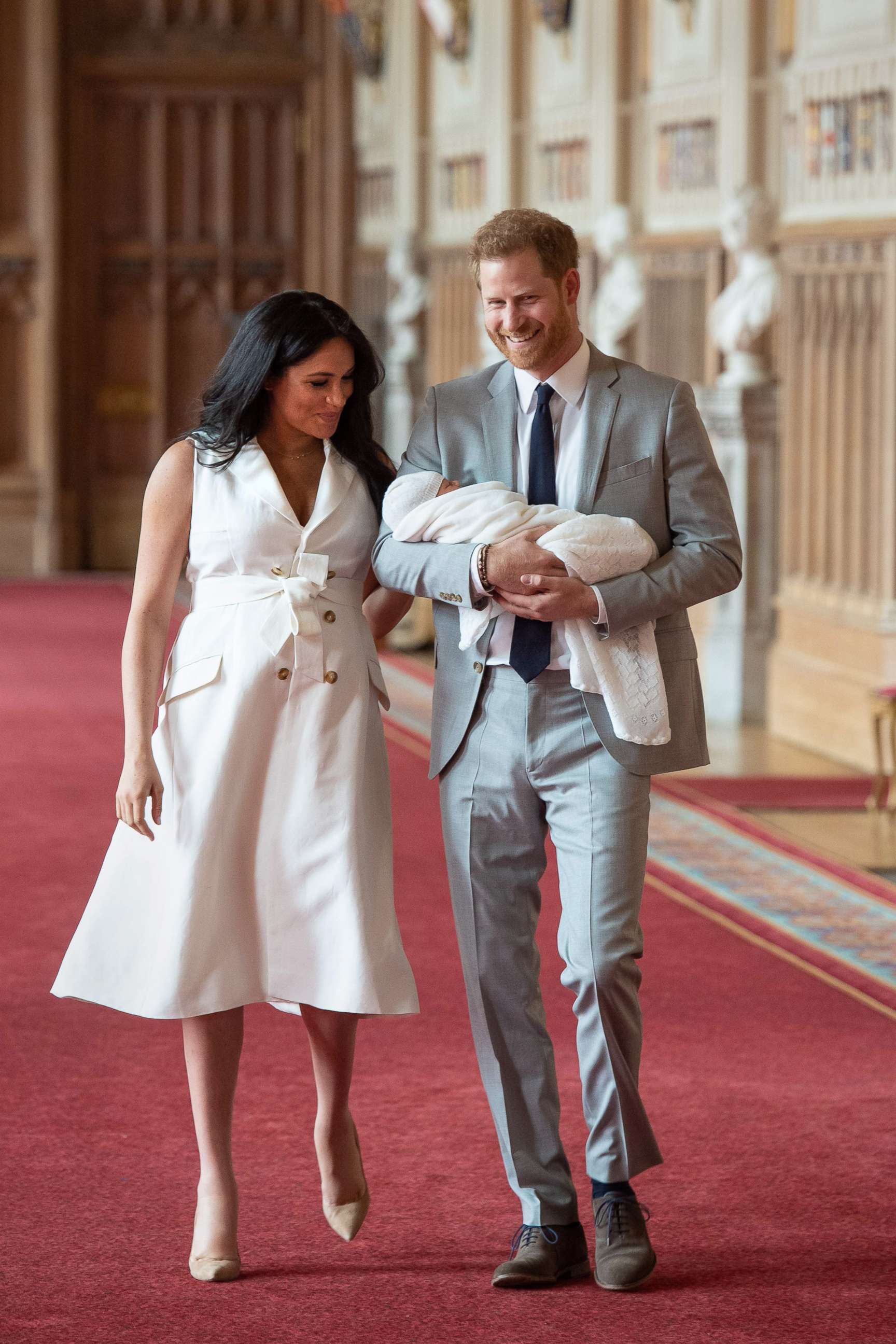 PHOTO: Britain's Prince Harry, Duke of Sussex and his wife Meghan, Duchess of Sussex, carry their newborn baby son in St George's Hall at Windsor Castle in Windsor, England, May 8, 2019.