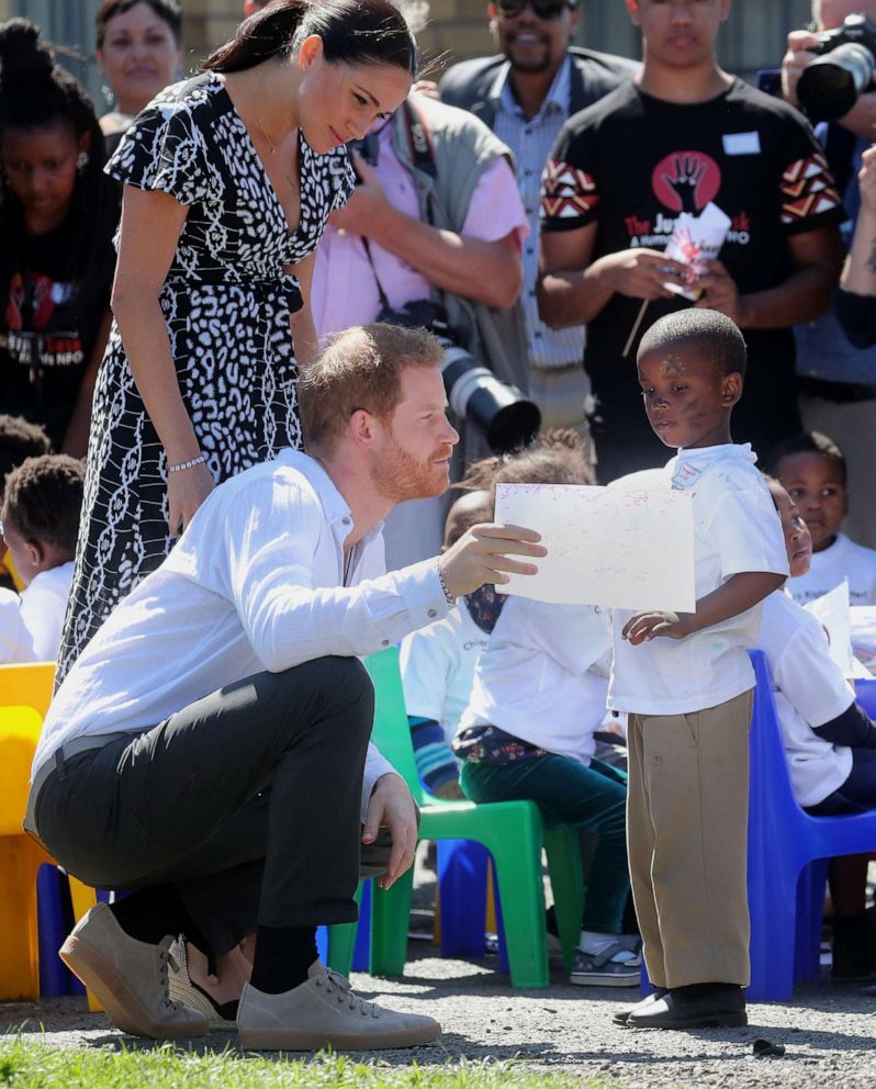 PHOTO: Meghan, Duchess of Sussex and Prince Harry, Duke of Sussex talk with a young boy during a visit to a Justice Desk initiative in Nyanga township, during their royal tour of South Africa, Sept. 23, 2019 in Cape Town.