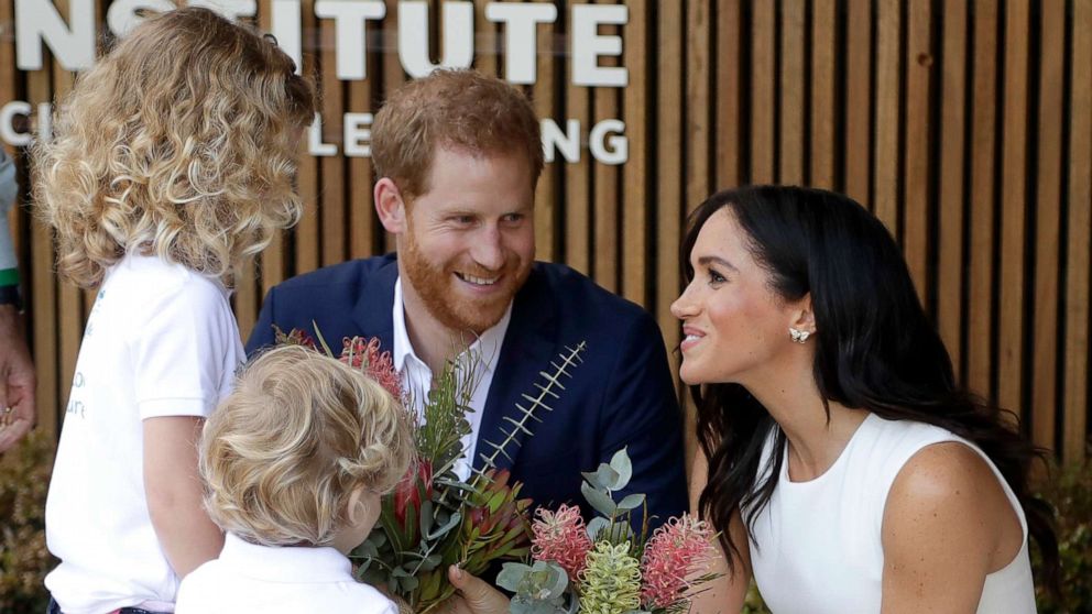 PHOTO: Prince Harry, Duke of Sussex and Meghan, Duchess of Sussex are presented with native flowers from children, Dasha Gallagher and Finley Blue, during a ceremony at Taronga Zoo, Oct. 16, 2018, in Sydney.