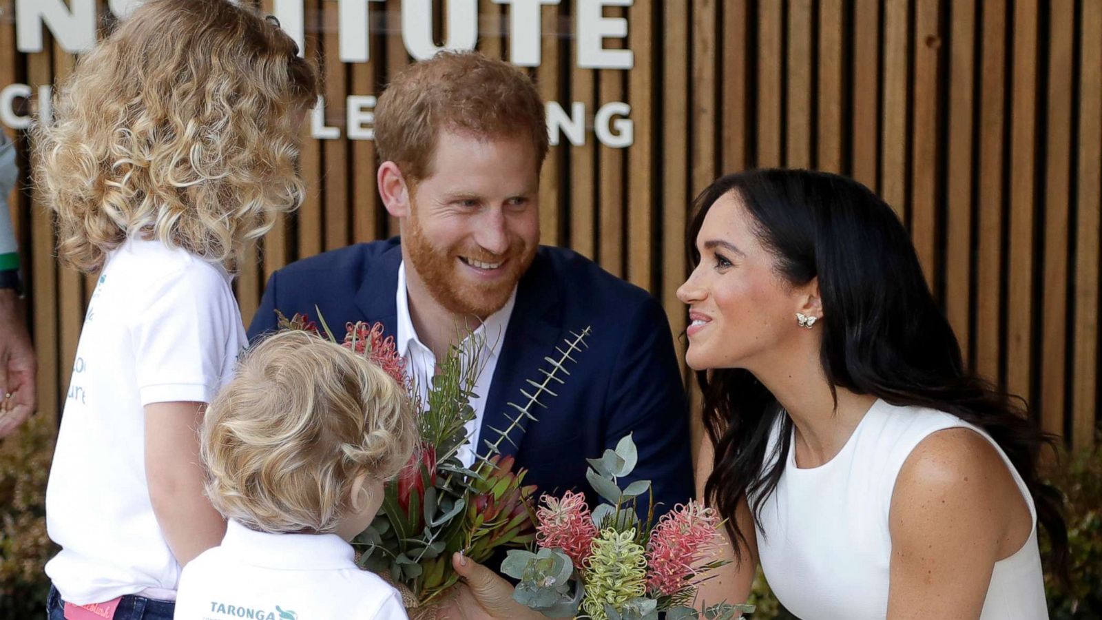 PHOTO: Prince Harry, Duke of Sussex and Meghan, Duchess of Sussex are presented with native flowers from children, Dasha Gallagher and Finley Blue, during a ceremony at Taronga Zoo, Oct. 16, 2018, in Sydney.