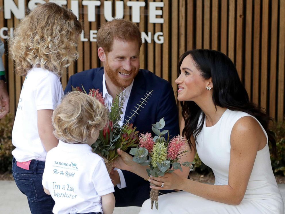 PHOTO: Prince Harry, Duke of Sussex and Meghan, Duchess of Sussex are presented with native flowers from children, Dasha Gallagher and Finley Blue, during a ceremony at Taronga Zoo, Oct. 16, 2018, in Sydney.