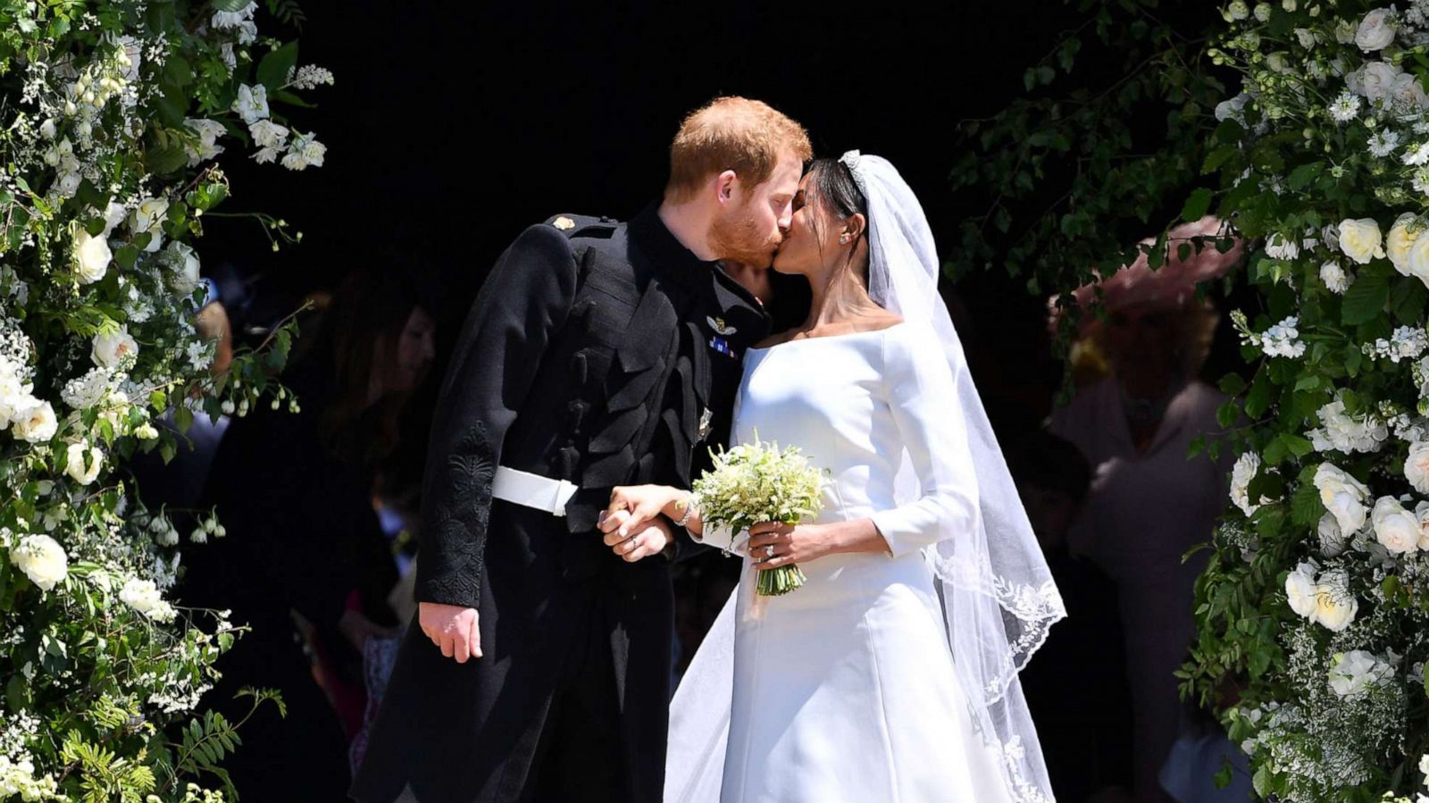 PHOTO: Britain's Prince Harry, Duke of Sussex kisses his wife Meghan, Duchess of Sussex as they leave from the West Door of St George's Chapel, Windsor Castle on May 19, 2018, in Windsor England.