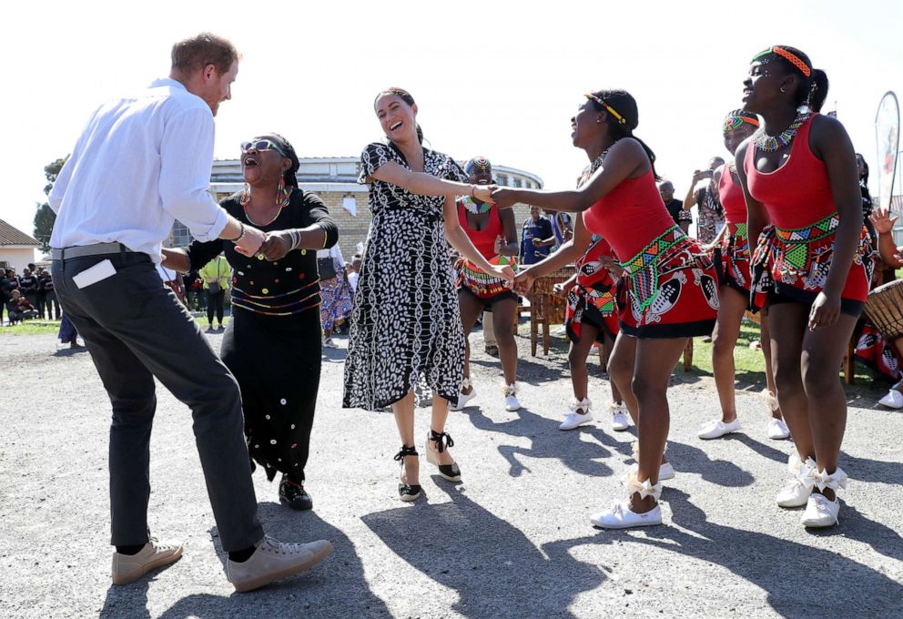 PHOTO: Prince Harry, Duke of Sussex and Meghan, Duchess of Sussex dance as they visit a Justice Desk initiative in Nyanga township, during their royal tour of South Africa on Sept. 23, 2019, in Cape Town, South Africa.