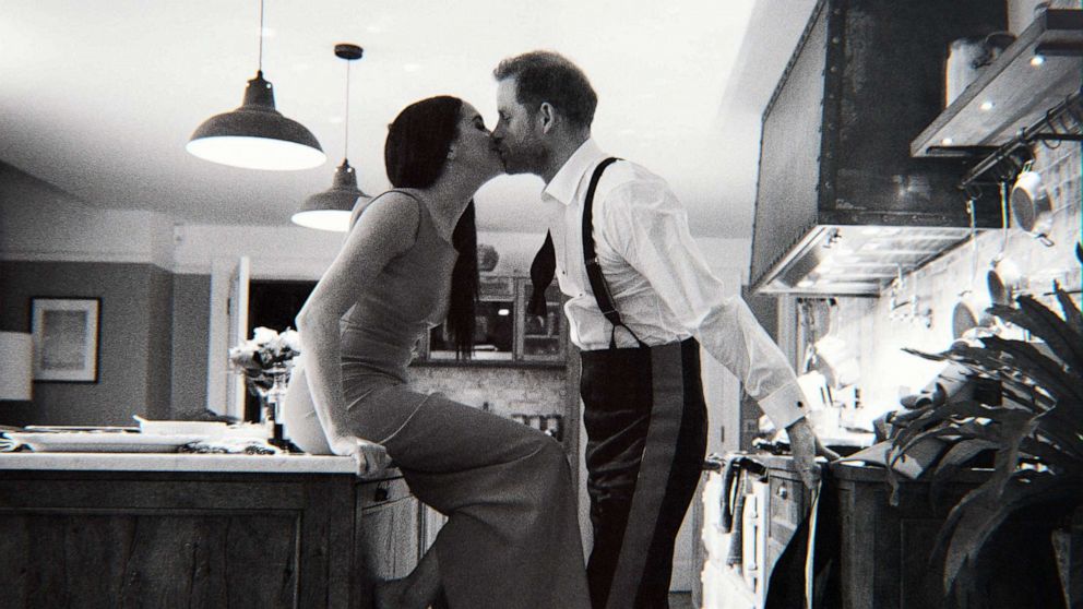 PHOTO: This undated and unlocated handout picture released by streaming platform Netflix shows Prince Harry and Meghan, The Duke and Duchess of Sussex, kissing in a scene from a documentary.