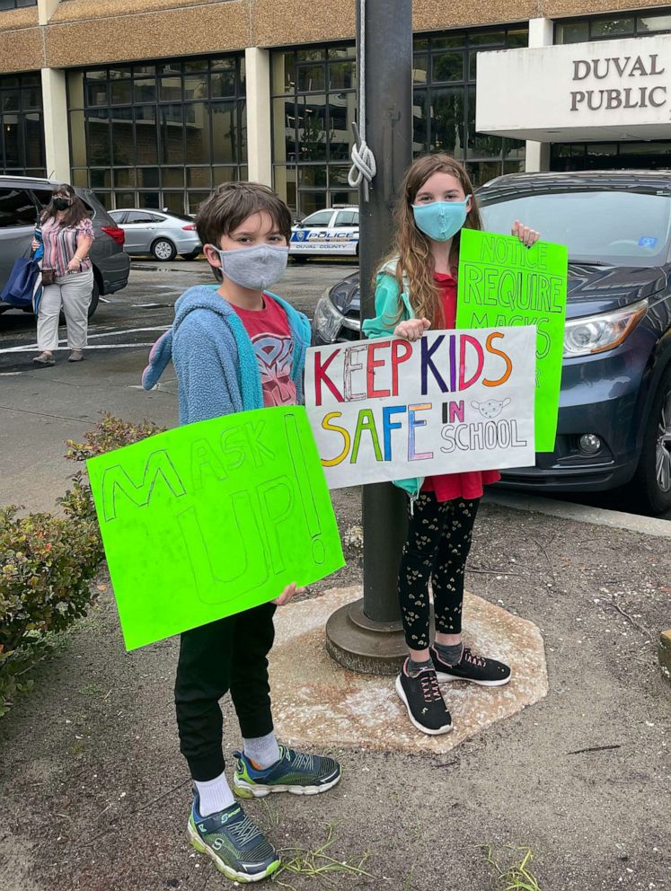 PHOTO: Will Hartley, 10, and Lila Hartley, 12, demonstrate in favor of masks outside of a Duval County Public Schools board meeting on August 3, 2021.