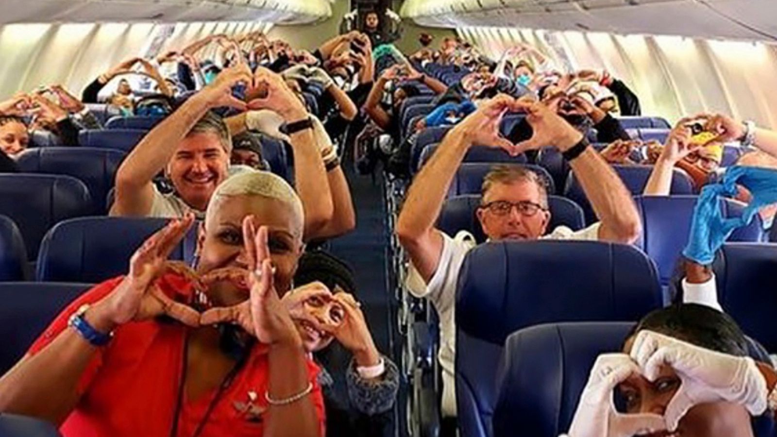 PHOTO: Health care workers, other passengers and flight crew aboard a Southwest flight from Atlanta to New York holding their hands in the shape of a heart at Hartsfield-Jackson Atlanta International Airport, March 27, 2020.