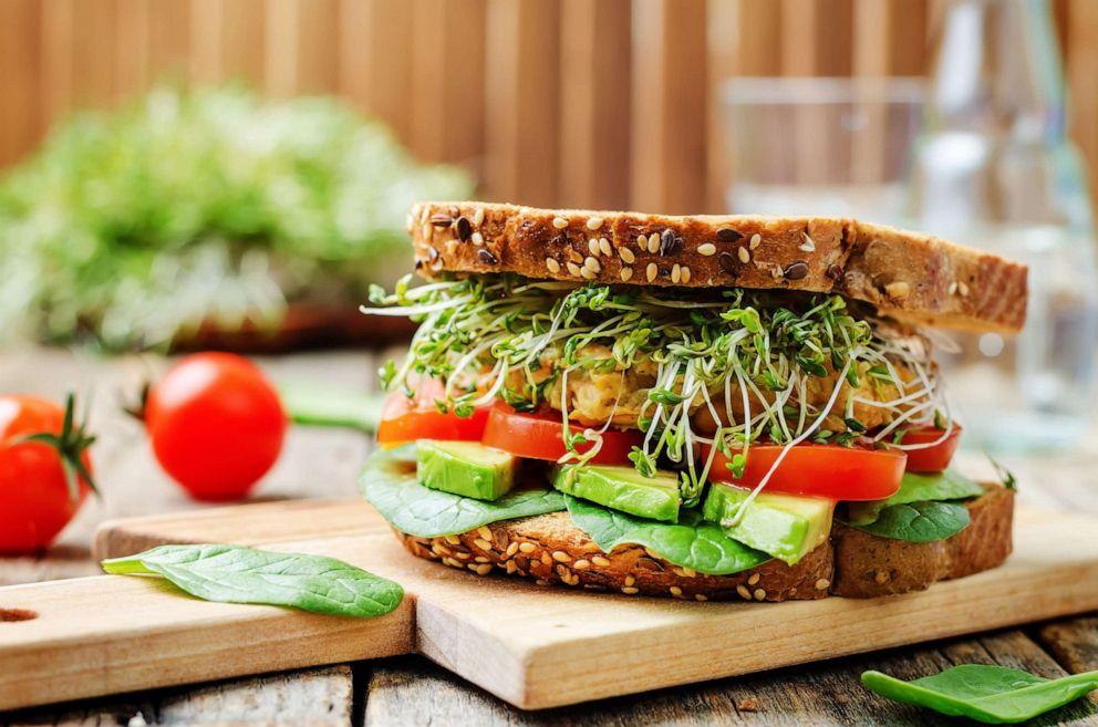 PHOTO: A healthy homemade sandwich with a chickpea burger, avocado, spinach, tomato, and sprouts.