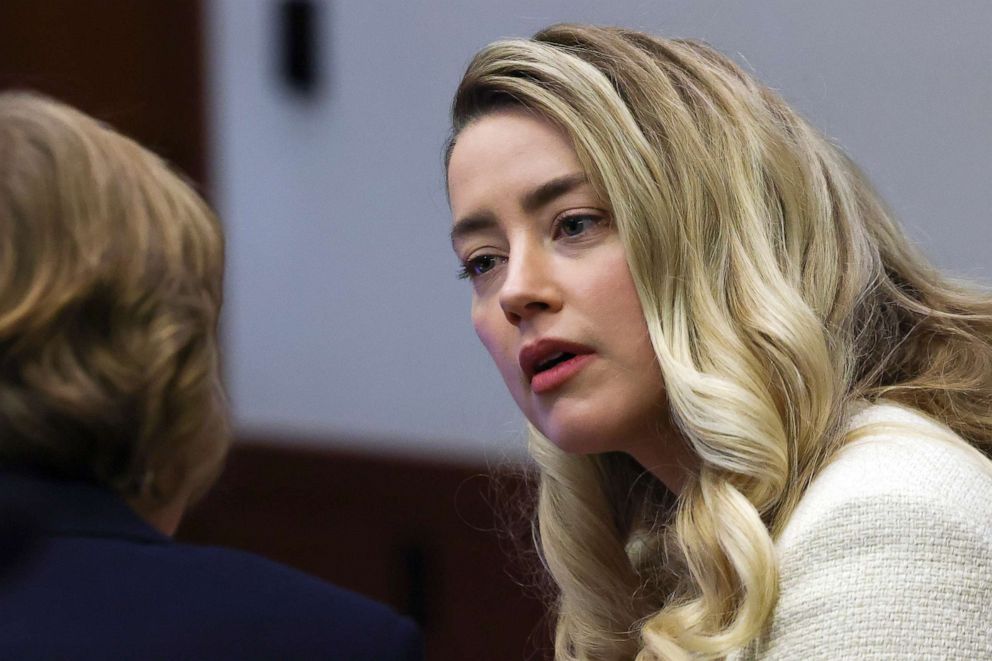 PHOTO: Actor Amber Heard speaks to her attorney during a hearing in the courtroom at the Fairfax County Circuit Court in Fairfax, Va., April 20, 2022. 