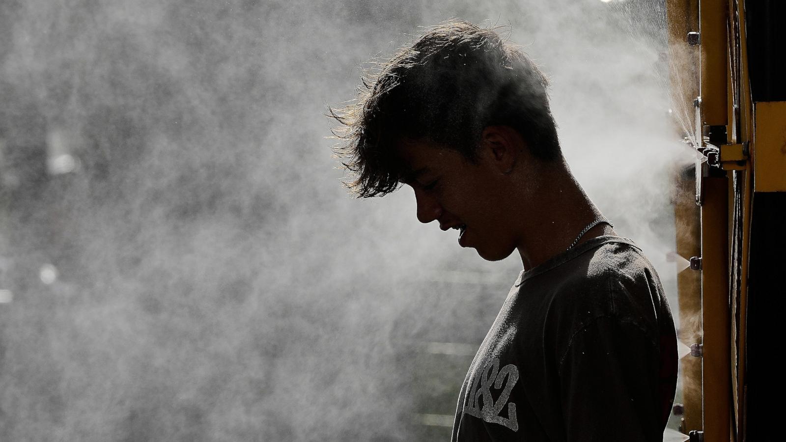 PHOTO: A person cools off in a mister as temperatures hit the mid 90's, June 30, 2026, in Kansas City, Mo.