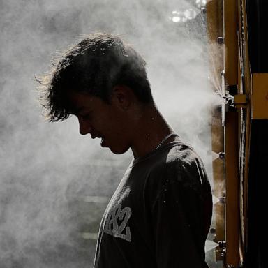 PHOTO: A person cools off in a mister as temperatures hit the mid 90's, June 30, 2026, in Kansas City, Mo.